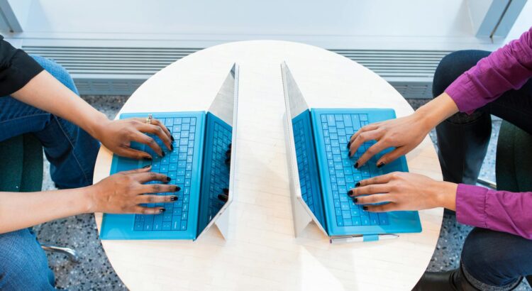 two people working on laptops